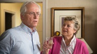 Helga reicht Hans ein Glas Wasser