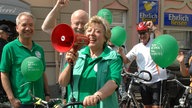 Helga sammelt ihre Mitstreiter am Umwelttag zur gemeinsamen Sternfahrt Richtung Marienplatz.