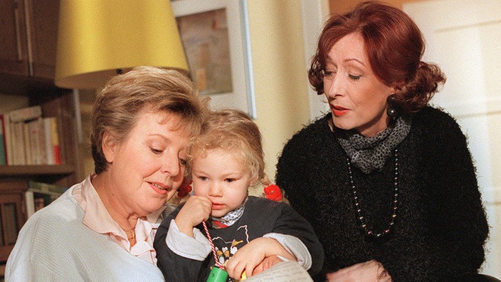 Helgas (Marie-Luise Marjan, li) Freundin Marlene (Renate Koehler) hegt starke Zweifel an der Herkunft des Kindes.