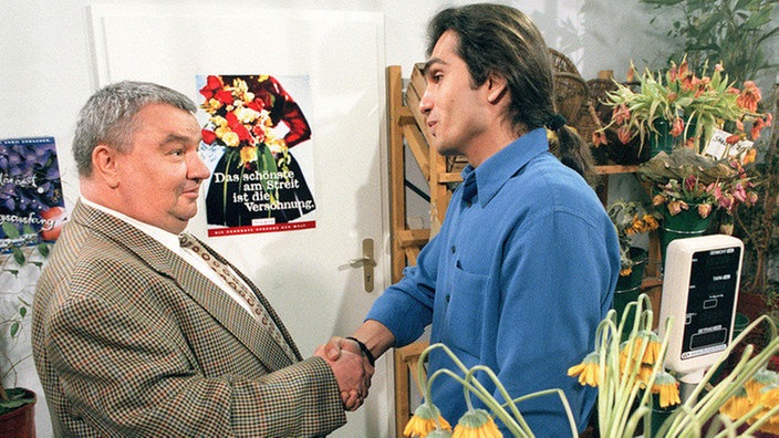 Herr Bayer (Norbert Wartha) verpachtet den Blumenladen an Vasily (Hermes Hodolides)