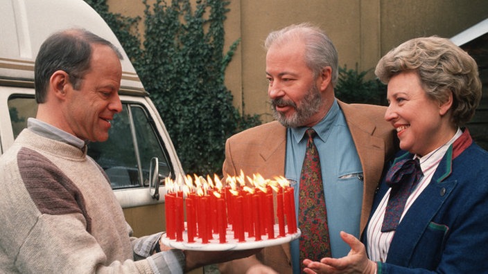 Herzlichen Glückwunsch! Helga (Marie-Luise Marjan) und Erich (Bill Mockridge, Mitte) gratulieren Hajo (Knut Hinz) zum Geburtstag.