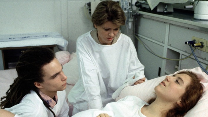 Iffis (Rebecca Siemoneit-Barum, rechts) Wehen haben eine Woche zu früh eingesetzt. Momo (Moritz Zielke) und Gabi (Andrea Spatzek) stehen ihr bei.