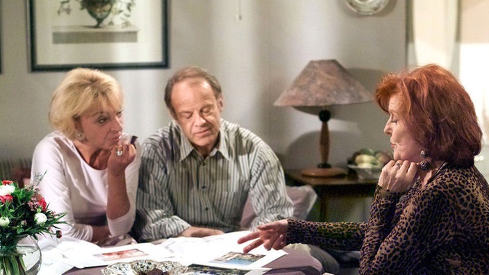 Isolde (Marianne Rogée, rechts) berichtet Berta (Ute Mora) und Hajo (Knut Hinz) von ihrem Plan, ein Haus auf Ischia zu kaufen. Derweil überschlagen sich im Haus Nr. 3 der Lindenstraße die Ereignisse.