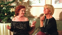 Isolde und Berta genießen Kekse vor dem Weihnachtsbaum