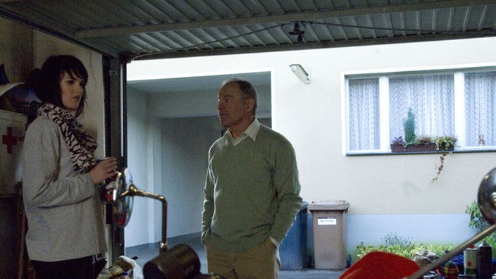 Jack (Cosima Viola) ist aus der Villa Dressler geflogen und in die Garage gezogen. Hajo (Knut Hinz) begutachtet das Übergangsdomizil.