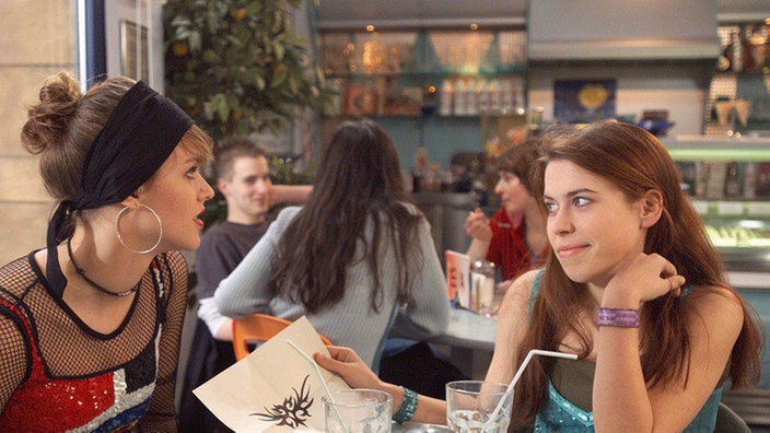 Jack (Cosima Viola, links) und Sarah (Julia Stark) haben gemeinsam ein Tattoo entworfen, das demnächst Jacks Körper schmücken soll. Sarah liebäugelt hingegen mit einem Piercing.