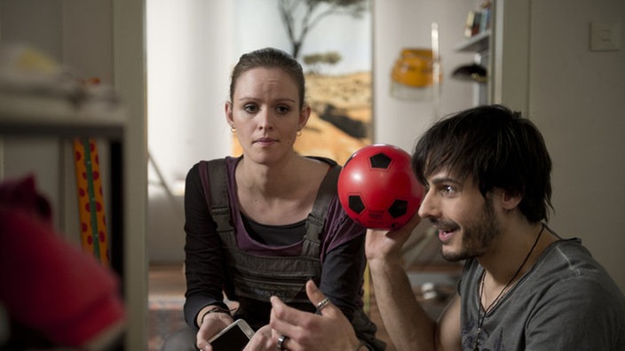 Jack schaut traurig zu Ben, der freudig Ball spielt