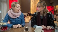 Jack und Sandra unterhalten sich im Café George
