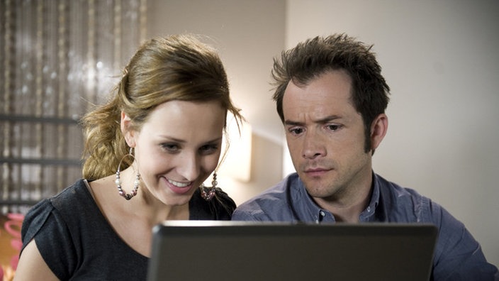 Josi und Alex schauen auf einen Laptop