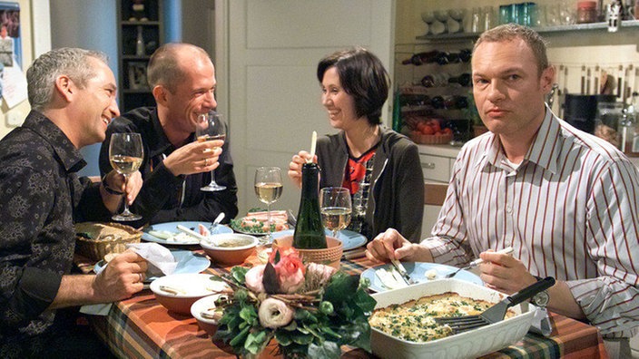 "Käthe" (Claus Vinçon, links), Carsten (Georg Uecker) und Urszula (Anna Nowak) haben ihren Spaß beim gemeinsamen Essen. Christian (Klaus Nierhoff, rechts) dagegen ist nur genervt.