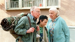 Kaum haben sich Herr Backhaus (Heinz W. Krückeberg, links) und Tom (Johannes Scheit) für ihren Wandertag das Ränzlein geschnürt, laufen sie auch schon der geschwätzigen Else Kling (Annemarie Wendl) in die Arme.