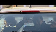 Kitty und Tom sitzen im Taxi und winken zum Abschied