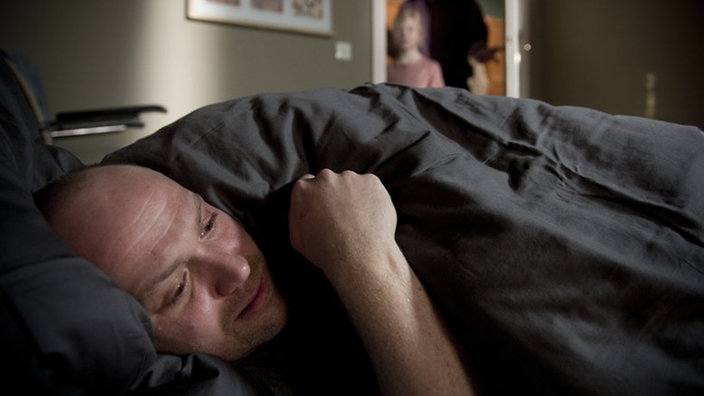Klaus liegt weinend in seinem Bett