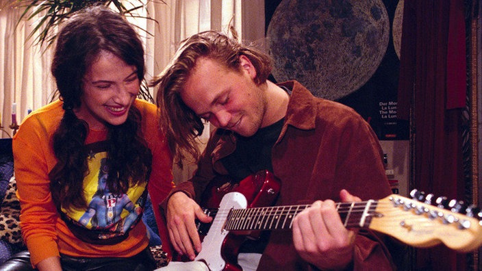 Klaus (Moritz A. Sachs) demonstriert Dani (Clelia Sarto), was seine Gitarre hergibt.