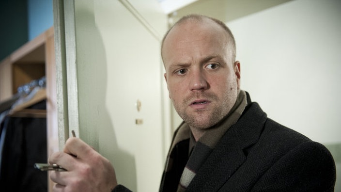 Klaus steht in der Wohnungstür mit dem Schlüssel in der Hand