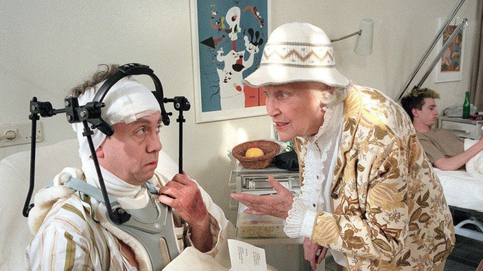 Kopfschmerzen: Else (Annemarie Wendl) besucht ihren Sohn Olaf (Franz Rampelmann) am Krankenbett. Offensichtlich zieht sich seine Genesung noch etwas hin.