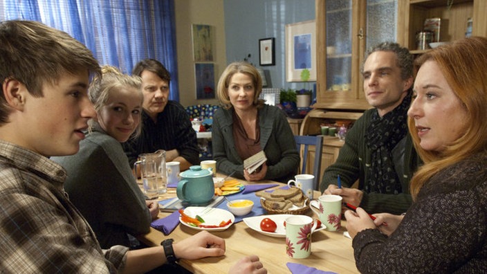 Krisengipfel der Familien Stadler und Zenker: Wie soll es weitergehen, wenn Caros und Nicos Kind auf der Welt ist? (v.l. Jeremy Mockridge, Cynthia Cosima, Christian Rudolf, Tanja Frehse, Moritz Zielke, Rebecca Siemoneit-Barum)