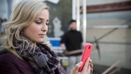 Lea ist zufrieden mit ihrem Foto, im Hintergrund steht Timo