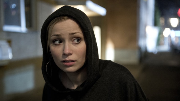 Lea läuft im schwarzen Kapuzenpulli durch die Nacht