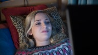 Lea liest etwas auf ihrem Laptop