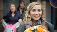 Lea steht mit einem Blumemstrauß vor Tanja und Lotti