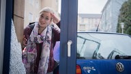 Lea steht vor der kaputten Scheibe