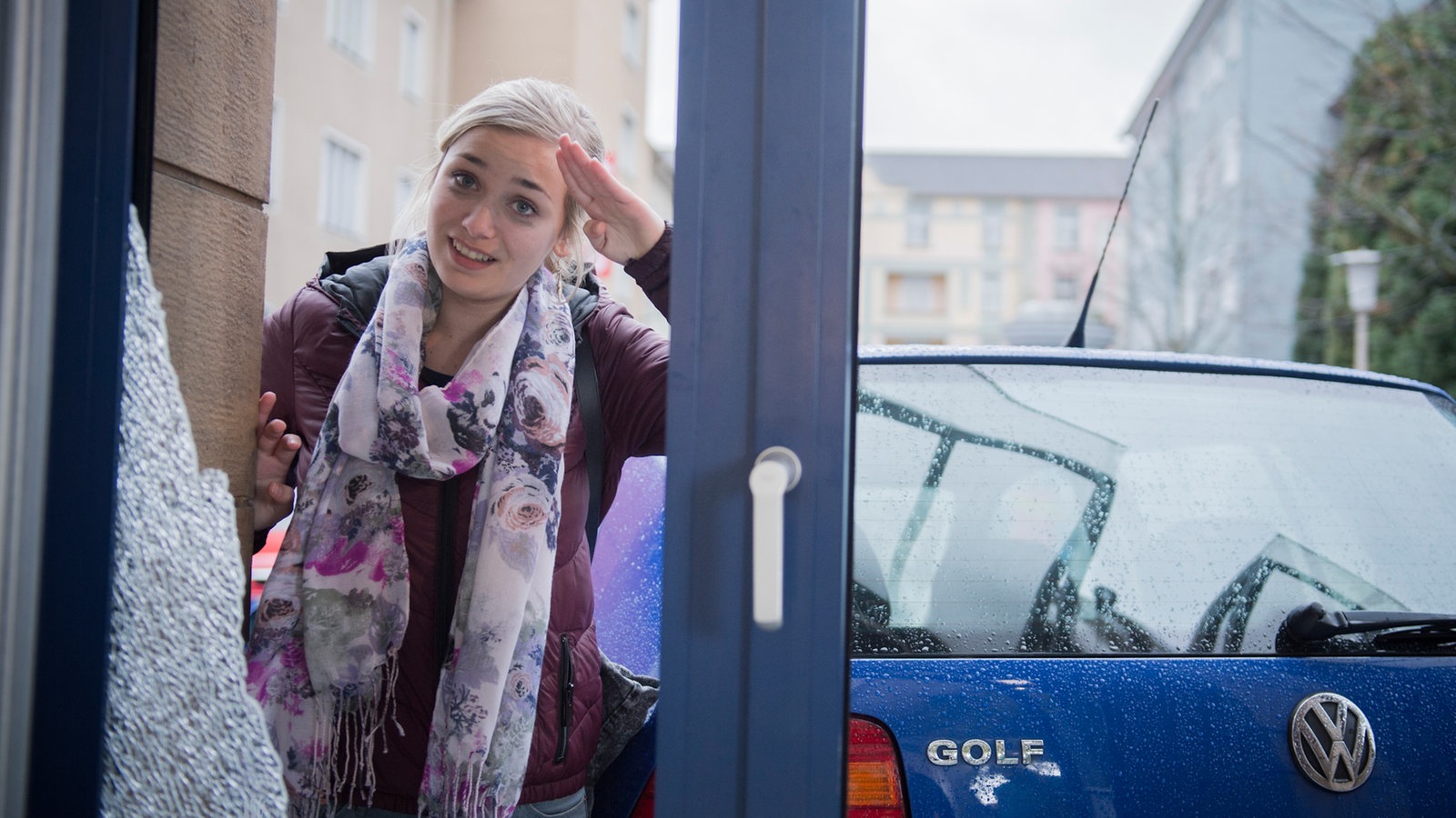 Lea steht vor der kaputten Scheibe