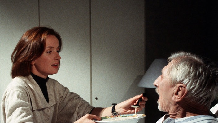 Liebevoll pflegen Anna (Irene Fischer) und Hans (Joachim Hermann Luger, links) den schwerkranken Willy Jenner (Hannes Kaetner).
