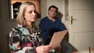 Lisa liest etwas und wird dabei von Murat betrachtet