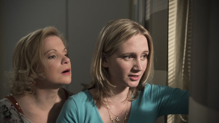 Lisa und Andrea beobachten etwas durch ein Fenster