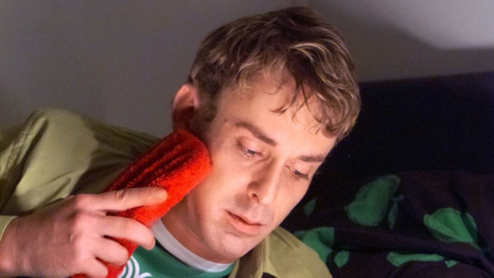 Lotti (Gunnar Solka) plagt sich mit Zahnschmerzen und Gedanken an Carsten.
