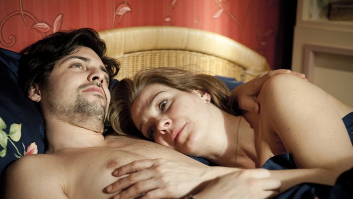Maria und Florin liegen eng umschlungen im Bett