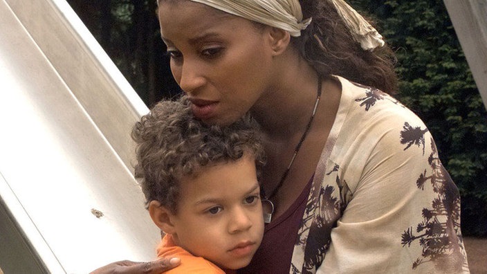 Mary (Liz Baffoe) hat Stress mit Bariya und Vasily. Trost spendet ihr in dieser schwierigen Situation ihr Sohn Nikos (Daniel Anih).