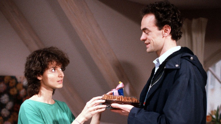 Matthias (Manfred Schwabe) schenkt Dominique (Brigitte Annessy) zum Einzug Brot und Salz.