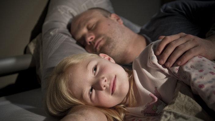 Mila liegt bei Klaus im Bett
