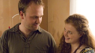 Mit einem lachenden und einem weinenden Auge betrachtet Klaus (Moritz A. Sachs) ein Ultraschallfoto seines gemeinsamen Kindes mit Nastya (Anja Antonowicz).