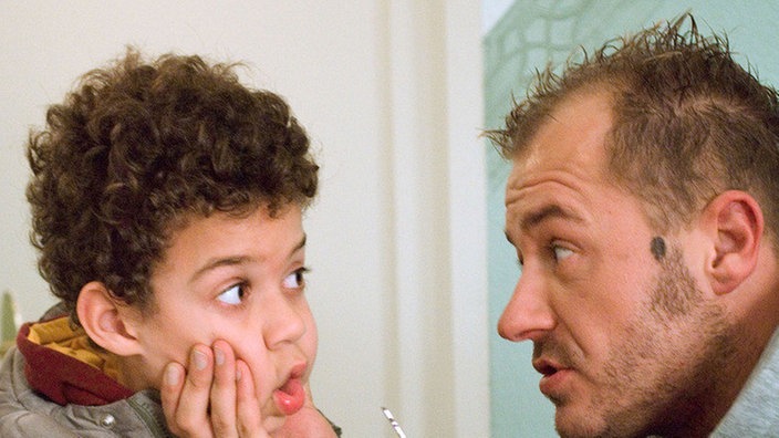Mit Gewalt: Olli (Willi Herren, rechts) zwingt Nikos (Daniel Anih), noch einmal in Rosis Wohnung einzudringen und deren EC-Karte zu stehlen.