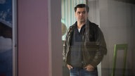 Murat guckt aus dem Reisebüro heraus