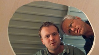Nicht rund und auch nicht schön: Klaus' (Moritz A. Sachs, links) Versuch, für Hans (Joachim Hermann Luger) ein Loch in die Torwand zu sägen, ist gescheitert.