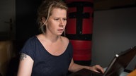 Nina guckt entsetzt auf einen Bildschirm