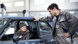 Nina und Enzo unterhalten sich in der Werkstatt