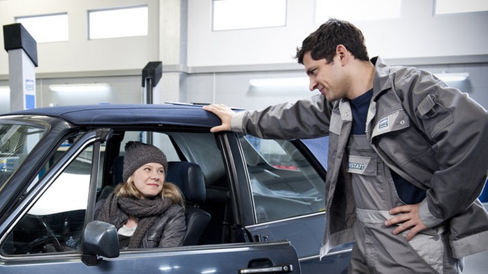 Nina und Enzo unterhalten sich in der Werkstatt