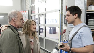 Nina und Hajo stehen mit Enzo in der Werkstatt