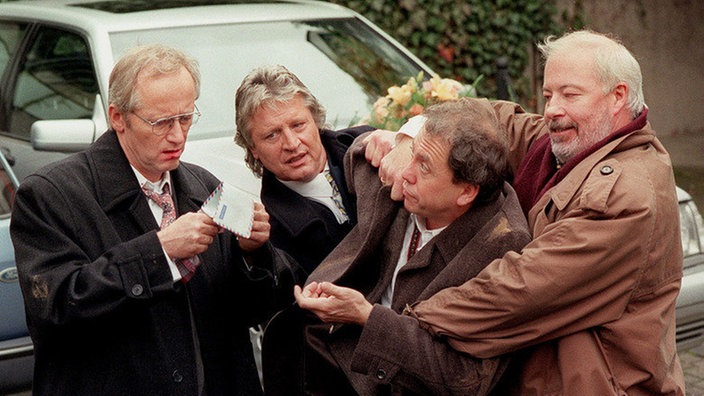 Nur mit Mühe kann Olaf Kling davon abgehalten werden, die Trauung zu stören (v.l.n.r.: Joachim Hermann Luger, Jo Bolling, Franz Rampelmann, Bill Mockridge).
