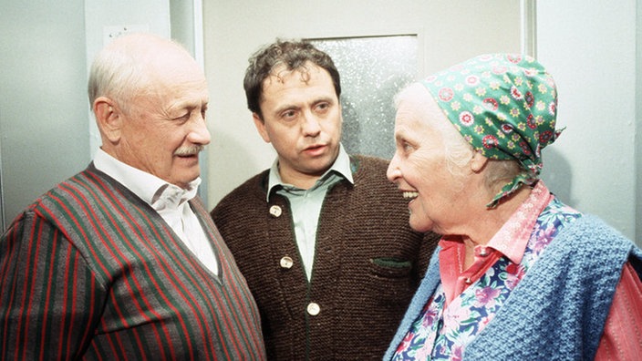 Olaf (Franz Rampelmann, Mitte) ist sauer auf seine Mutter (Annemarie Wendl). Franz Wittich (Martin Rickelt) amüsiert sich darüber.