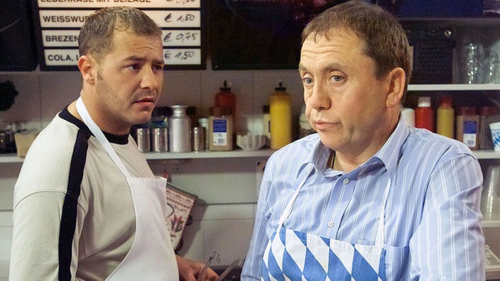 Olli (Willi Herren, links) hat starke Zweifel an dem Preis, den Olaf (Franz Rampelmann) für seine Verlobungsfeier im "Café Bayer" zahlen soll. Will Gabi Zenker mit dieser Preisvorstellung die Verlobung verhindern?