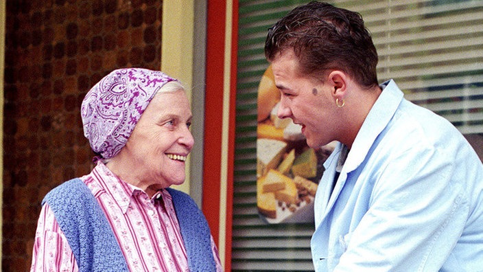 Olli (Willi Herren) zeigt sich von seiner besten Seite und trägt Else (Annemarie Wendl) die Einkaufstüten nach Hause.