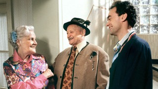 Onkel Franz (Martin Rickelt, links) und Matthias (Manfred Schwabe) gratulieren der überraschten Else (Annemarie Wendl) zum Geburtstag.