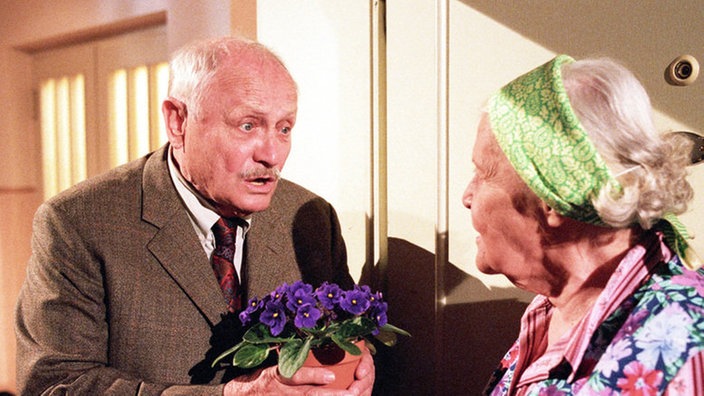 Onkel Franz (Martin Rickelt) versucht Elses (Annemarie Wendl) Groll mit Usambaraveilchen zu erweichen