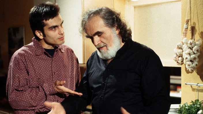 Panaiotis (Kostas Papanastasiou, rechts) erklärt Vasily (Hermes Hodolides), dass den Menschen in Georgien geholfen werden muss.